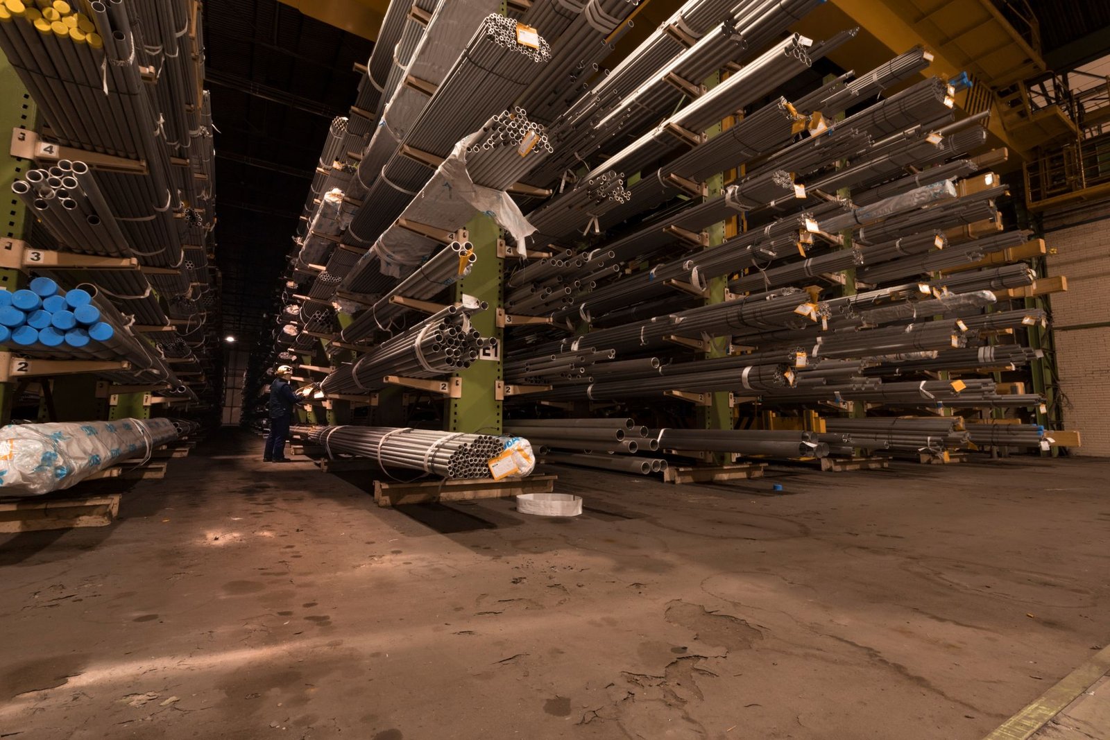 Large industrial warehouse stocked with steel tubes